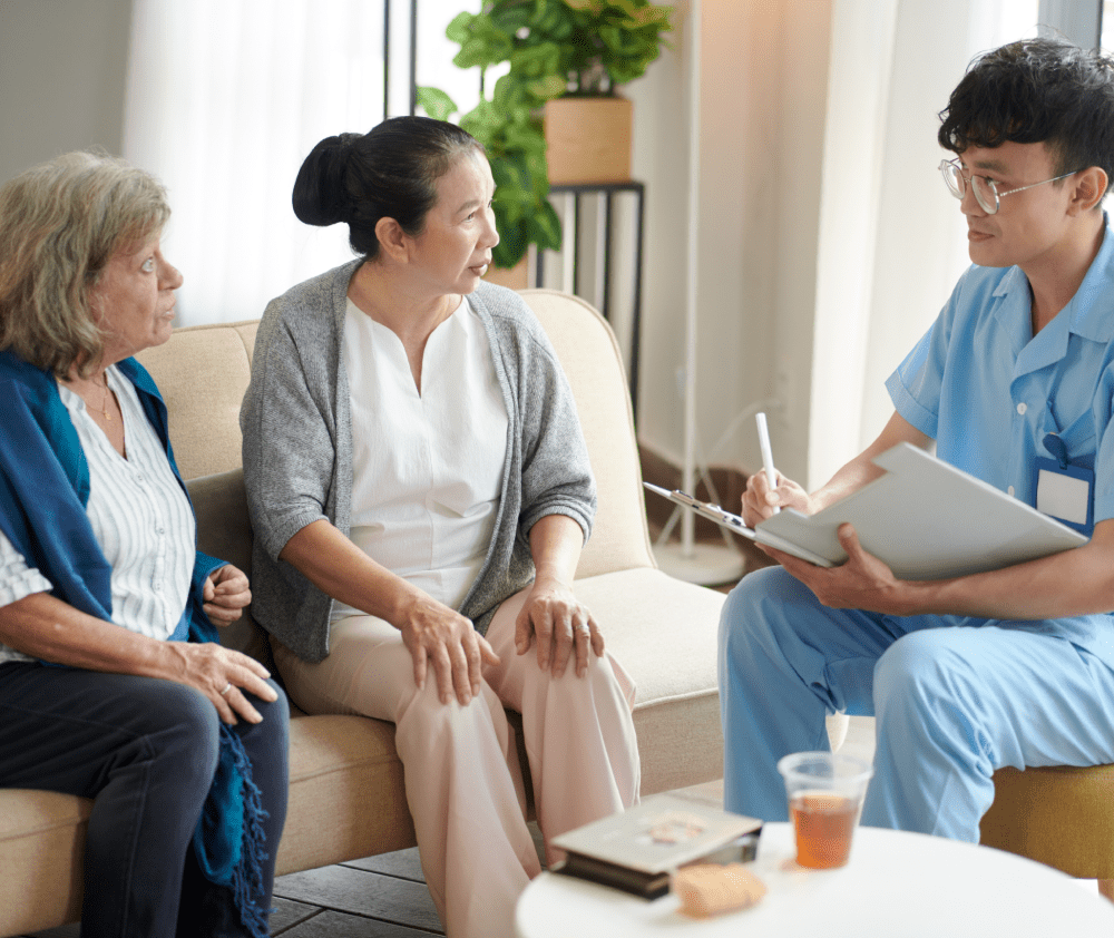 Nursing home doctor talking to senior patients and taking notes in document Nursing home doctor talking to senior patients and taking notes in document