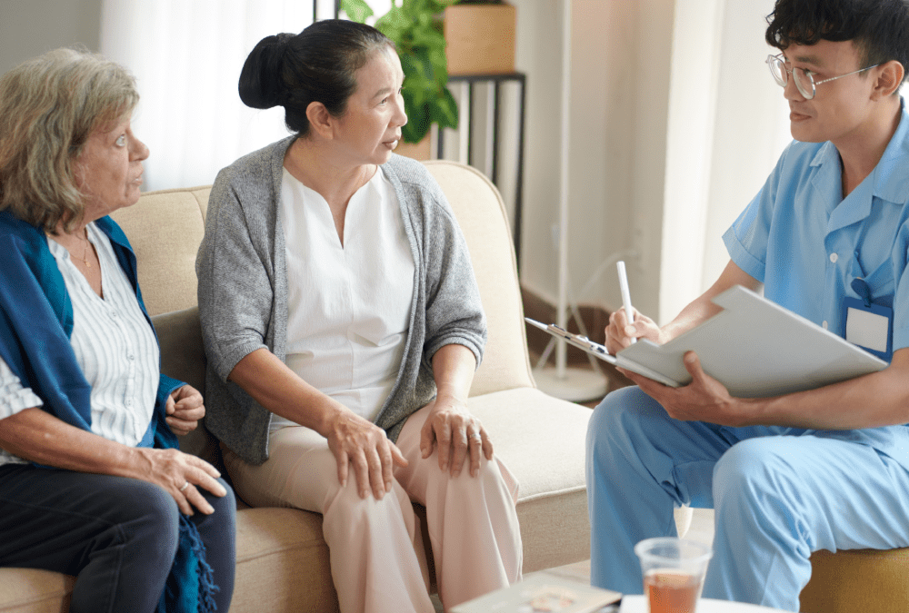 Nursing home doctor talking to senior patients and taking notes in document